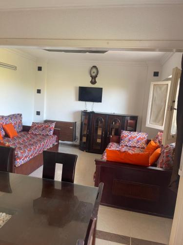 a living room with two couches and a television at للعائلات فقط شاليه بالدور الاول كامل الفرش تكييف بالساحل الشمالى in Dawwār Muḩammad Abū Shanab