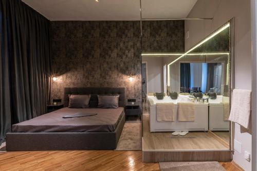 ein Schlafzimmer mit einem Bett, einem Waschbecken und einem Spiegel in der Unterkunft Luxury Vitosha Apartment in Sofia