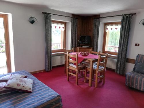 a living room with a table and chairs in a room at Residence Pavou in Cogne
