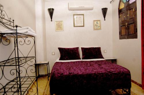 ein Schlafzimmer mit einem Bett in einem Zimmer in der Unterkunft Sindi Sud in Marrakesch