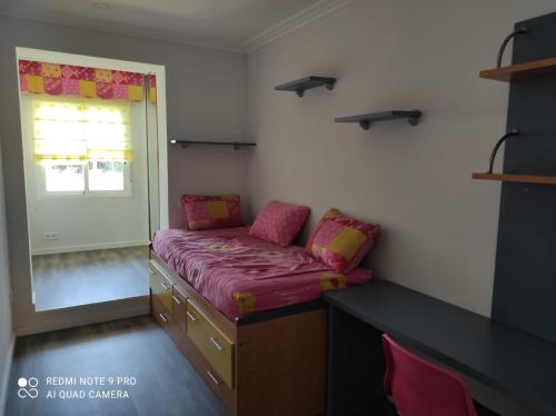 Cette chambre comprend un lit, un bureau et une fenêtre. dans l'établissement La Terraza de Castelao, à O Grove
