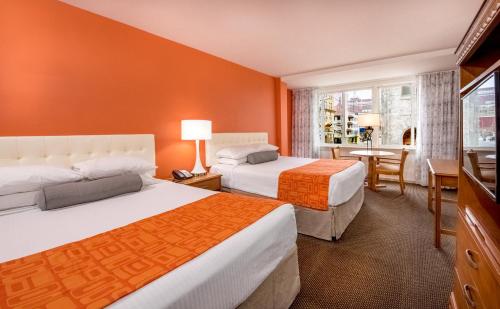 a hotel room with two beds and a desk at Howard Johnson by Wyndham Atlantic City in Atlantic City