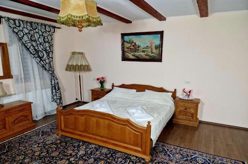 sypialnia z drewnianym łóżkiem i dywanem w obiekcie Mehadica House w mieście Mehadica
