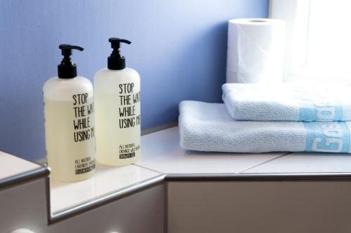 two bottles of soap and towels on a counter in a bathroom at Hotel Bären in Marbach am Neckar