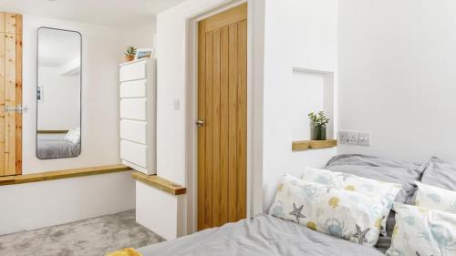 un dormitorio con una cama y un espejo en Once Upon A Tide, en Bude