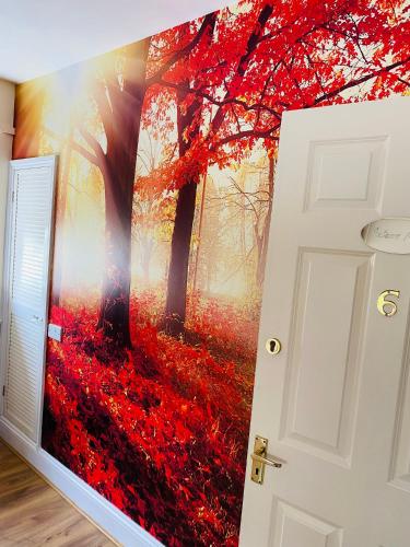 a wall mural of a forest with red leaves at All Seasons Bed & Breakfast - Adults Only in Weston-super-Mare