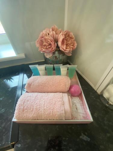 a table with towels and a vase with a flower at All Seasons Bed & Breakfast - Adults Only in Weston-super-Mare