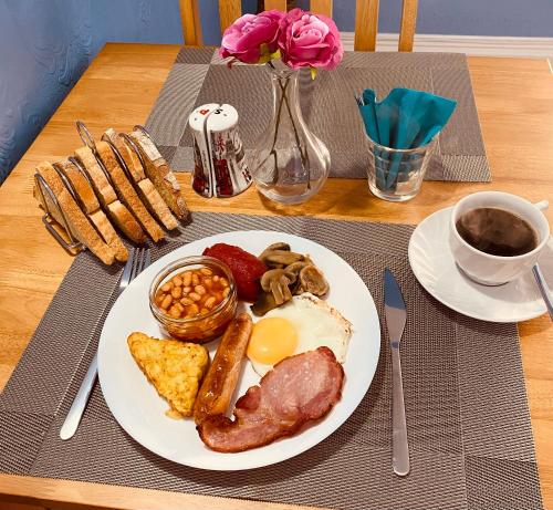 a table with a plate of breakfast food on a table at All Seasons Bed & Breakfast - Adults Only in Weston-super-Mare