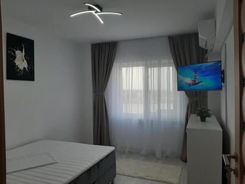 Apartament DeltaView Deluxe Sulina في سولينا: غرفة نوم بسرير وتلفزيون بشاشة مسطحة