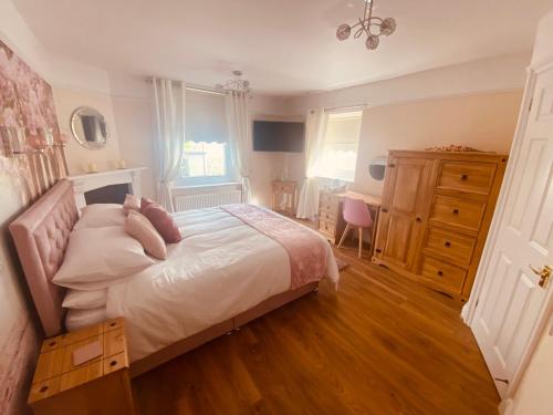 a bedroom with a bed with a dresser and a desk at All Seasons Bed & Breakfast - Adults Only in Weston-super-Mare