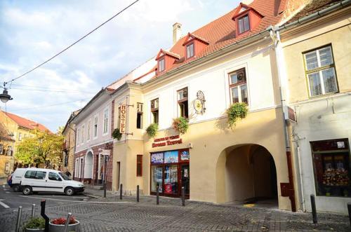 uma rua com um carro branco estacionado em frente a um edifício em Hostel PanGeea em Sibiu