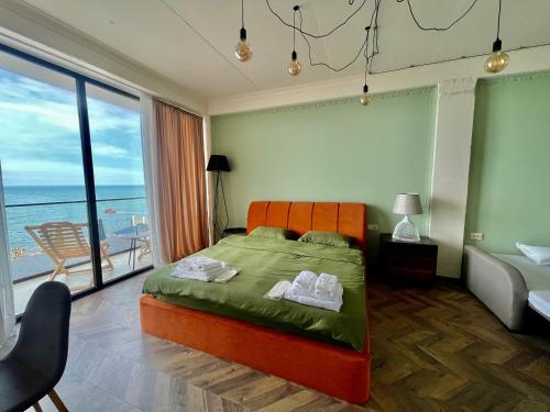 1 dormitorio con cama y vistas al océano en Claude Monet Seaside Hotel en Grigoleti
