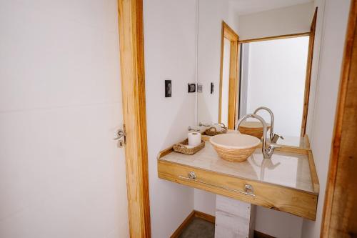 a bathroom with a sink and a mirror at Cabañas Valle de los Ciervos in Tandil