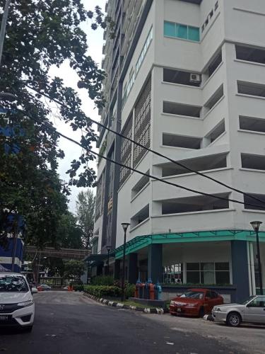 a street with cars parked in front of a building at VUE RESIDENCE - 2 ROOMs in Kuala Lumpur