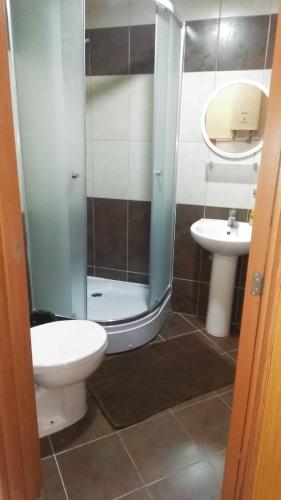 uma casa de banho com um chuveiro, um WC e um lavatório. em apartment24 em Skopje