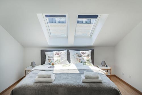 um quarto com uma cama grande e 2 janelas em City Lodge Vienna em Viena