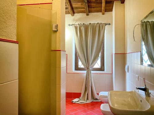 a bathroom with a sink and a toilet and a window at Villaluce Wine Agriturismo in Castiglione del Lago