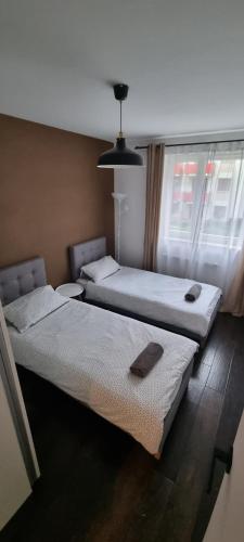 dwa łóżka w pokoju z oknem w obiekcie Green Apartments Kraków w Krakowie
