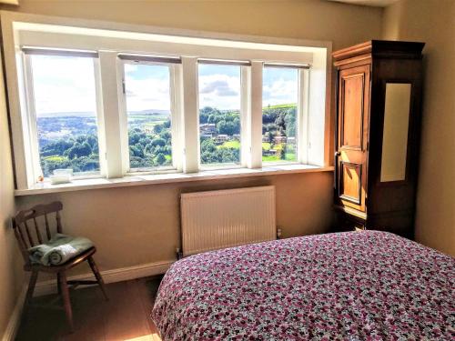 a bedroom with a bed and a window with a view at Ginnel Corner in Golcar