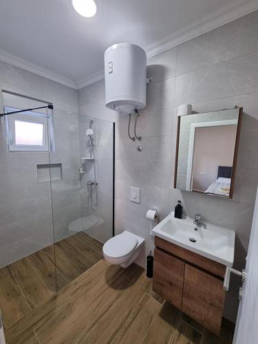 a bathroom with a toilet and a sink and a shower at Medjugorje Apartments Centre in Međugorje