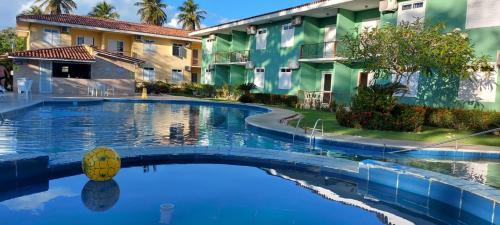 a swimming pool in front of a building at Praia Boulevard Flat Porto Bahia in Porto Seguro