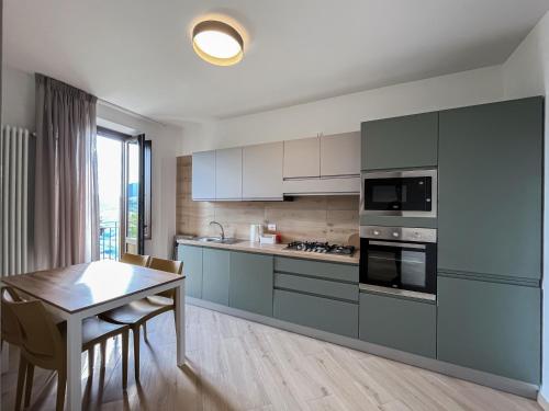 a kitchen with grey cabinets and a table and a table and chairs at Residenza Sant'Angelo - Bike&Trekking House in Pietrapertosa