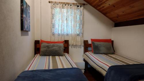a small room with two beds and a window at RIFUGIO DEL TRAMONTO in Monte Verde