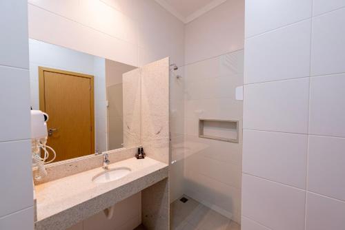 W łazience znajduje się umywalka i lustro. w obiekcie Gaben Hotel w mieście Jaú