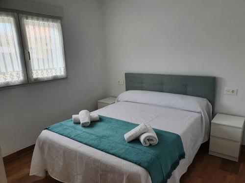 um quarto com uma cama com toalhas em vivienda vacacional casa tames em Ribadesella