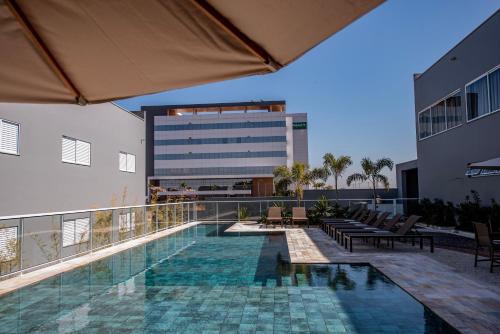 a balcony with a swimming pool and a building at Gaben Hotel in Jaú