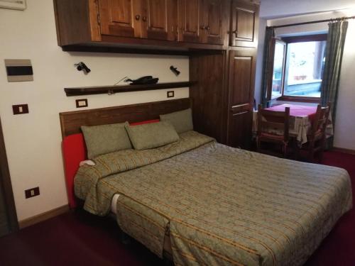 a bedroom with a bed and a table and a window at Residence Pavou in Cogne