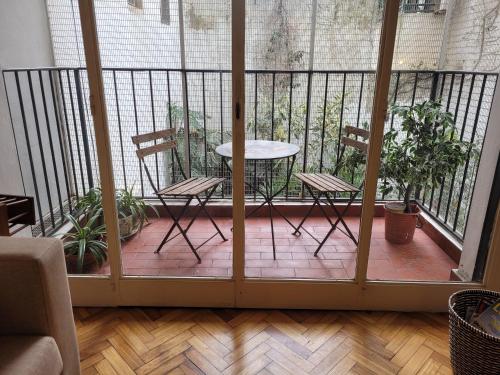a patio with two chairs and a table on a balcony at Recoleta Time in Buenos Aires