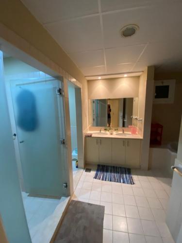 bagno con doccia, lavandino e specchio di Spacious 4-bedroom villa, children friendly a Dubai