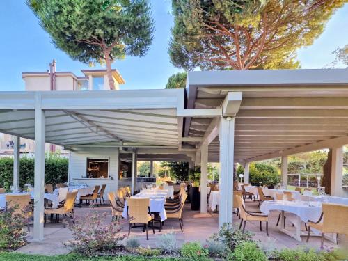 un restaurante con mesas y sillas bajo un pabellón en Hotel Villa Elsa, en Marina di Massa