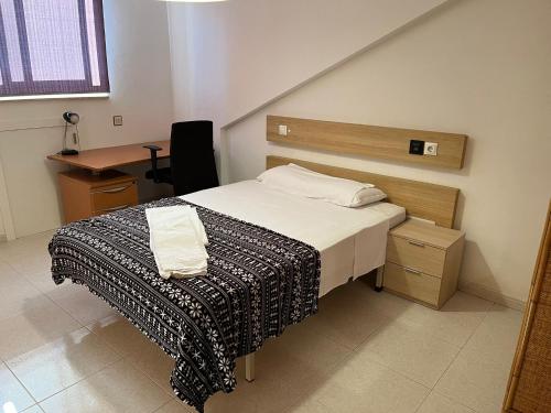mała sypialnia z łóżkiem i biurkiem w obiekcie Residencia Vista Alegre w Santiago de Compostela