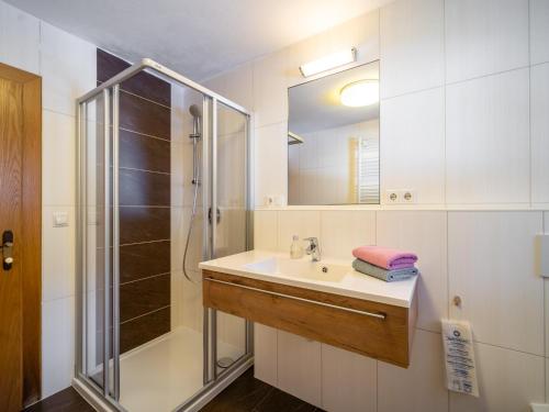 ein Bad mit einem Waschbecken und einer Dusche in der Unterkunft Tiroler Gästehaus in Zell am Ziller