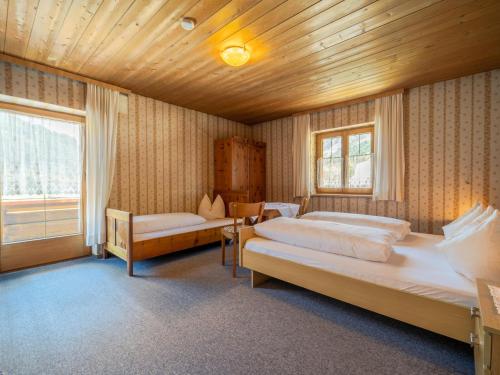 ein großes Schlafzimmer mit 2 Betten und einem Fenster in der Unterkunft Tiroler Gästehaus in Zell am Ziller
