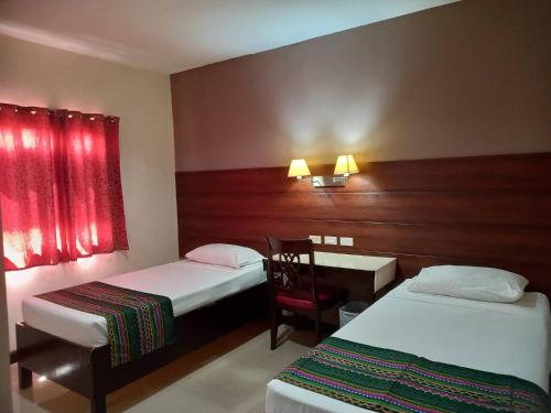 サンボアンガにあるW Hotelのベッド2台、デスク、テーブルが備わる客室です。