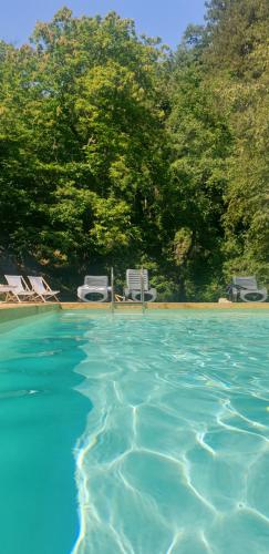 a large swimming pool with chairs and trees at Villaggio Barilari in Minucciano