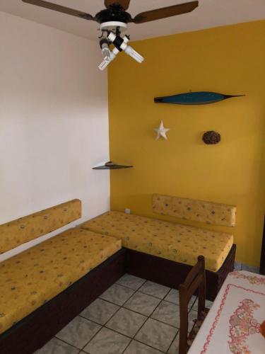 a room with two beds and a ceiling fan at Chalés Alencar in Caraguatatuba