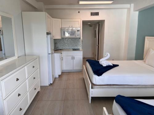 a bedroom with a bed and a kitchen with white cabinets at Ocean Front Units at Miami Beach in Miami Beach