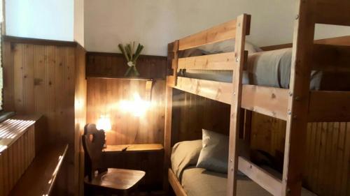 een slaapkamer met 2 stapelbedden en een bureau bij Villaggio Barilari in Minucciano