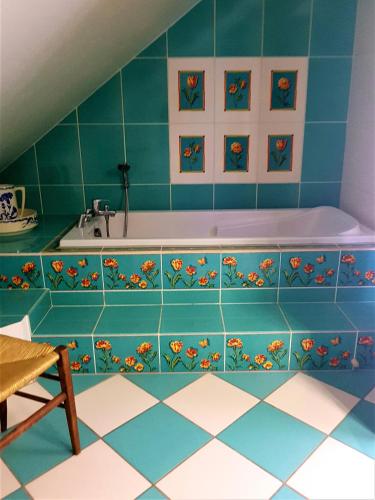 a bath tub in a bathroom with blue tiles at GEO 2 in Horbourg