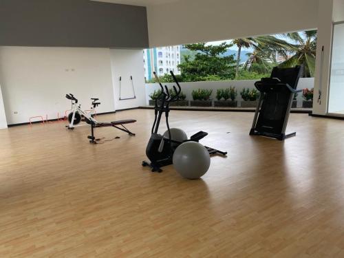 a gym with exercise bikes and exercise balls on a wooden floor at Edificio Sierra Beach Resort Pozos Colorados vista y salida al mar in Santa Marta