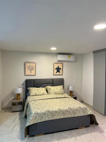 a bedroom with a large bed and two tables at Hotel Taganga Plaza Santa Marta in Taganga