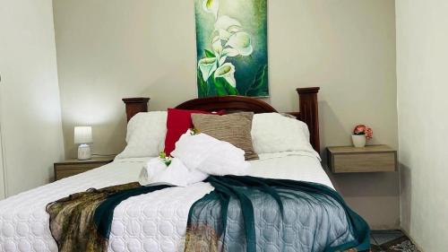 una camera da letto con letto, lenzuola e cuscini bianchi di Montaña de Paz a San Ramón Sur