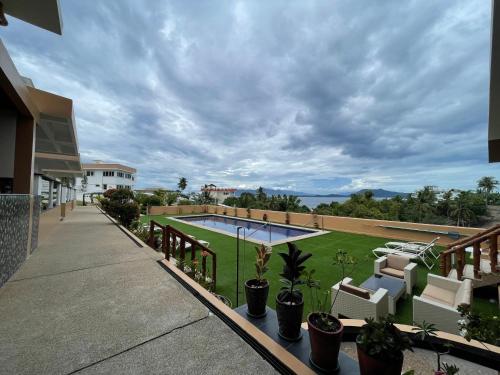 a balcony with a view of a swimming pool and plants at Verde View Villas in Puerto Galera