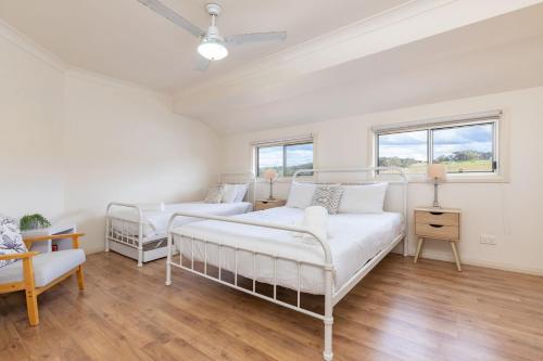 a white room with two beds and a couch at The Gem 39B Emerald Drive in Diamond Beach