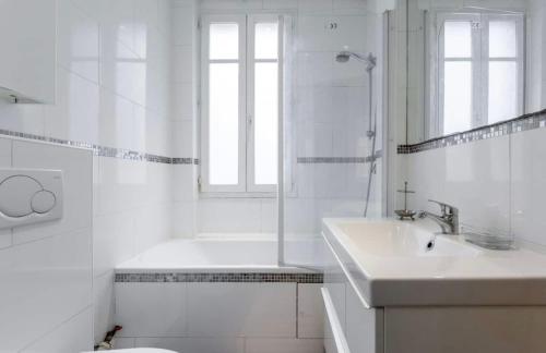 une salle de bain blanche avec une baignoire et un lavabo dans l'établissement Beautiful apartment in center Paris, à Paris
