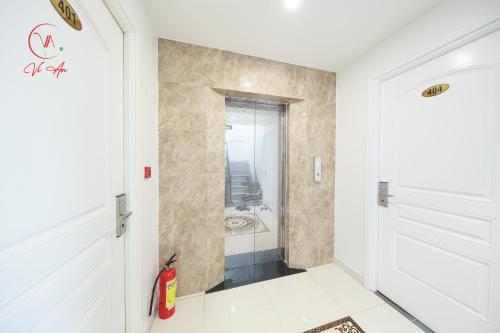 uma casa de banho com uma porta branca e um espelho em Vi An Hotel em Ho Chi Minh